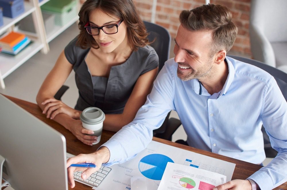 Real Estate Investors Review 9 Point Market Evaluation Plan Together At Desk